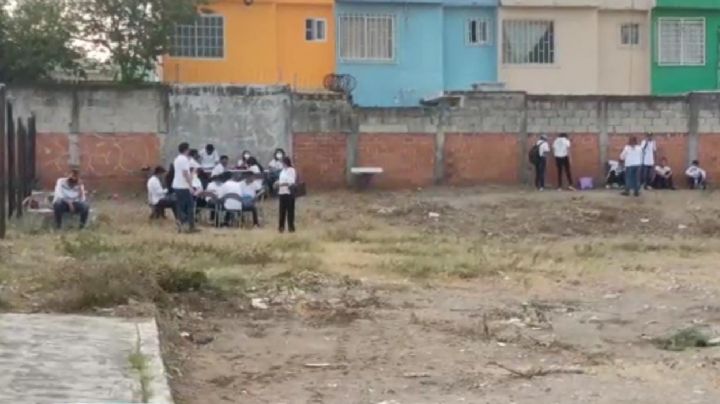 Por falta de aulas estudiantes de Telesecundaria del puerto de Veracruz toman clases bajo un árbol